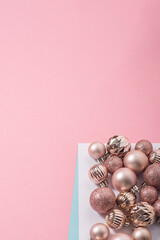 Beautiful shiny pink decorative balls on a pink background. Top view, flat lay.
