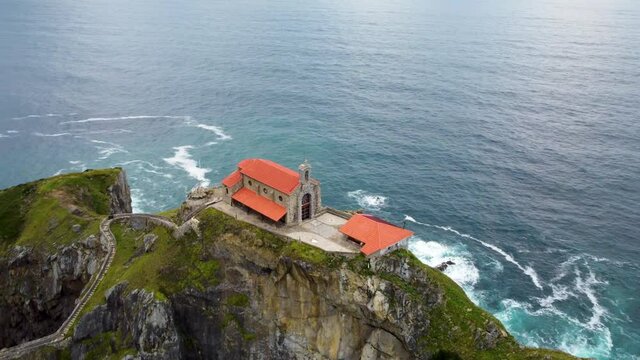 Ermita de San Juan de Gaztelugatxe. Catholic church at the bank of the Atlantic ocean. Drone flight over the rocky island, Bakio, Spain.