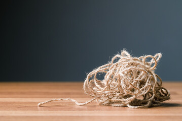 Tangled jute rope on the table, concept for complicated or complex issue - obrazy, fototapety, plakaty