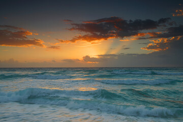 sunrise with light from behind the cloud and reflection in the ocean