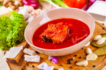 Borscht with vegetables and meat in pink plate. Ukrainian cuisine