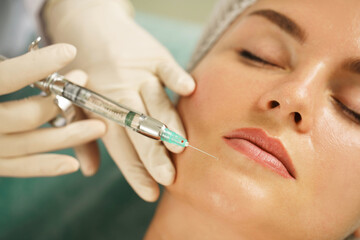 Woman getting injection of local anesthetic before facial surgery in a medical aesthetic clinic
