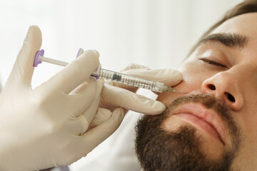 Male client during filler injections in a clinic