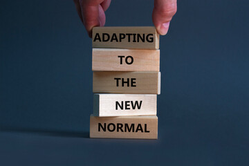 Adapting to the new normal symbol. Wooden blocks with words Adapting to the new normal on beautiful...