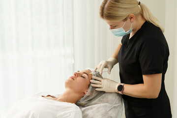 Woman during biorevitalization procedure in aesthetics medical clinic