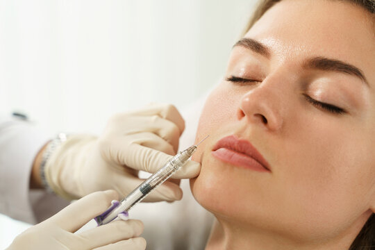 Woman during facial filler injections in aesthetic medical clinic