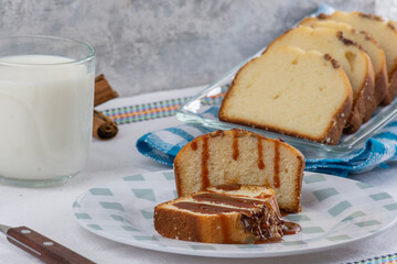 close up of walnut bread with cajeta on a plate, accompanied by a glass of milk