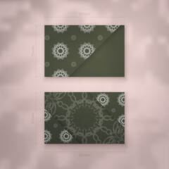Business card template in dark green color with vintage white ornaments for your personality.