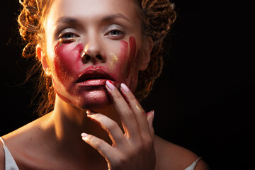 Red paint is like blood on the skin, face art and creative makeup, blood on the face of a...
