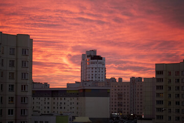 Fototapeta premium Dawn in the city. Multi-storey buildings and the sky in red and blue are visible.