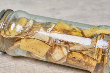 A jar filled with banana peel cuts and water. Banana peel for plant fertilization. Eco friendly natural way of fruit waste compost. Banana peel compost