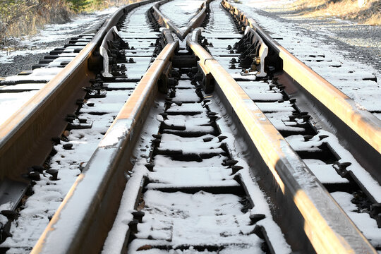 Image of an empty winter railroad track stretching far away. Crossing railway tracks. Narrow gauge railway.