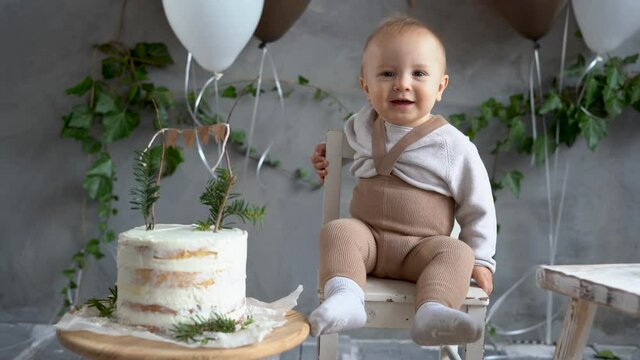 Boy's first birthday, festive background with balloons and a delicious cake, natural rustic style, one year old baby. Happy birthday.