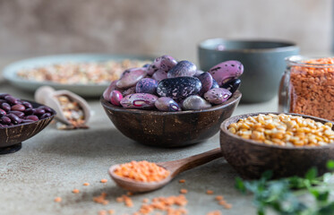 Assortment of beans and lentils on concrete background. The concept of healthy and nutritious food. Vegan high protein product.