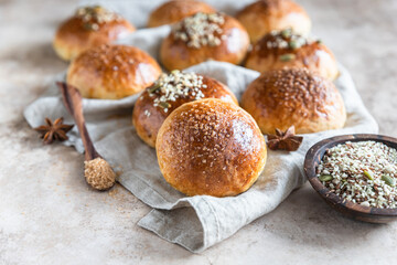 Fresh homemade pumpkin buns with brown sugar or seeds, light concrete background. Autumn bakery.