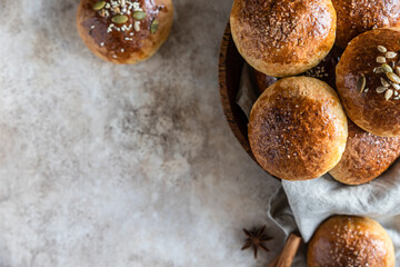 Fresh homemade pumpkin buns with brown sugar or seeds, light concrete background. Autumn bakery.