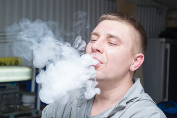 A man smokes a vape. Smoke from electronic cigarettes.