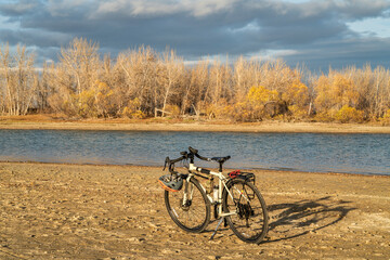 Fototapeta premium fall biking, touring or commuting - bicycle on a lake beach, Boyd Lake State Park in northern Colorado, November scenery