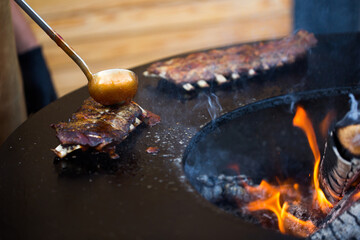 Fototapeta premium Grilled pork baby ribs with barbecue sauce on the grill. Festival street food