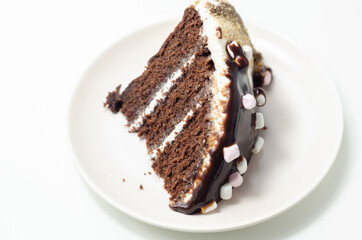 Chocolate sponge cake, coated and filled with marshmallow flavour frosting, chocolate flavour frosting, decorated in the digestive crumb with chocolate sauce and marshmallows