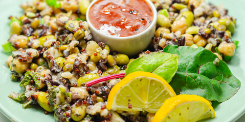 Obraz na płótnie Canvas Cooked edamame beans, chickpeas, pearl barley, red quinoa, mung beans and black rice in a refreshing lemon dressing