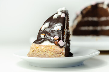 Chocolate sponge cake, coated and filled with marshmallow flavour frosting, chocolate flavour frosting, decorated in the digestive crumb with chocolate sauce and marshmallows