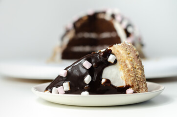 Chocolate sponge cake, coated and filled with marshmallow flavour frosting, chocolate flavour frosting, decorated in the digestive crumb with chocolate sauce and marshmallows