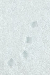 Natural  abstract background  made of ice cubes in the snow. Pastel white winter pattern. Minimal flat lay with copy space. Freezing or refreshing concept. Note card idea.