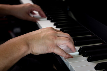 A man hands playing piano by press finger on white key for melody chord during music practice lesson. Classical music instrument.