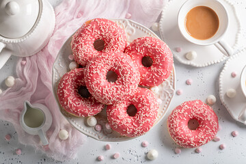 Homemade and sweet pink donuts and coffee as best dessert.