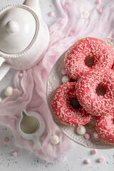 Homemade and sweet pink donuts and coffee as perfect snack.