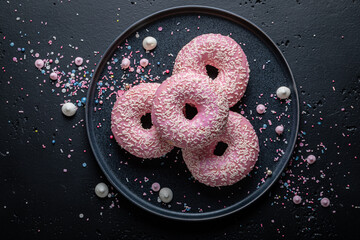 Homemade and delicious pink donuts as takeaway dessert