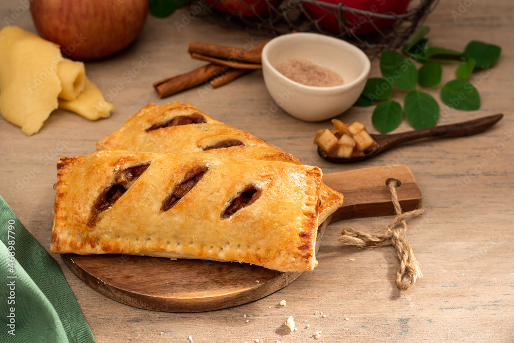 Wall mural Baked apple hand pie in wooden background