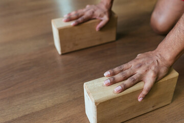 Fototapeta na wymiar Close-up of a young man's hand holding wooden blocks for yoga and fitness.