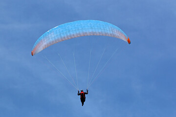 Paraglider in a blue sky	