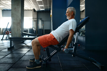 Tired old man with towel leisures after workout