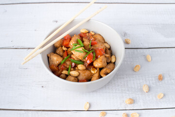 Rice with spicy kung pao chicken on a plate.
