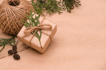 Festive decoration of gifts in eco-style.Gift boxes are wrapped in craft paper,tied with cotton thread,decorated with thuja leave,cones and burlap.Christmas,New Year and eco-friendly concept,copyspace