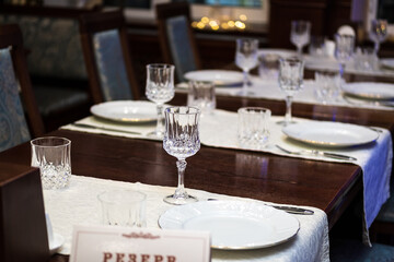 Served tables with a tablecloth, plates, glass