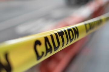 Construction caution tape close up, city road work.