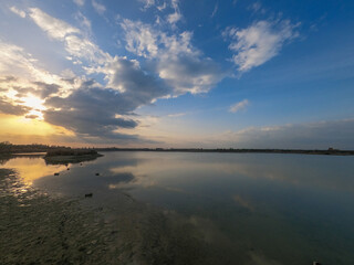 sunset at coast of the lake. Sunset sky. Smooth water