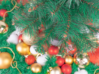 Christmas background with a green tree, red and gold balls. Merry Christmas greeting card concept.