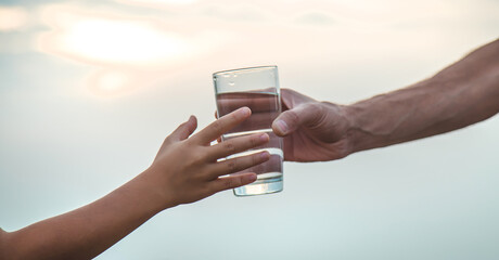 Father and child with a glass of water. Selective focus.