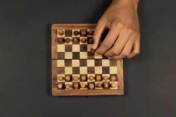 hand moving a black piece in a chess game