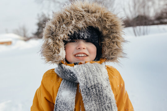 Close-up, image of a happy child in a hood in winter looking at the camera