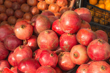 Fototapeta na wymiar Lots of red pomegranates on the counter