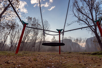 Abandoned swing in a park on a cold winter morning.