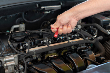 Fototapeta na wymiar man checking car oil level. preventive vehicle maintenance