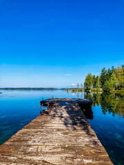 Obraz premium a wooden way leading to e blue lake in finland