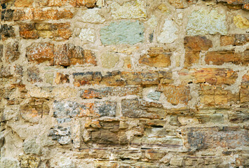 old stone wall of yellow brick with holes